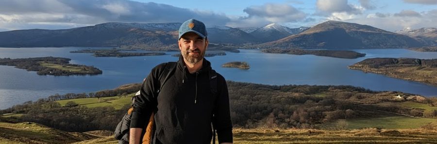 GÖRKEM ÖZTAŞ, outdoors on a hillside overlooking a loch and mountains